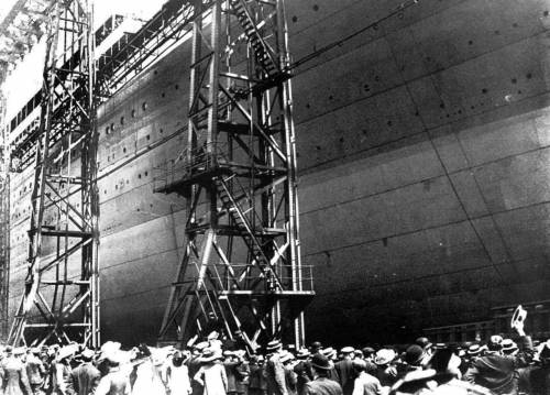 31 мая 1911 года. За секунды до спуска на воду.  Сотни гостей (в основном представители высшего класса) наблюдают спуск непосредственно возле Титаника, в то время как многие тысячи наблюдают за спуском издалека с берегов доков H&W.