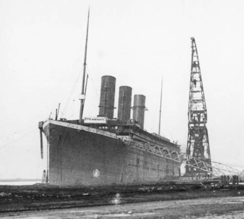 Это редкое фото было сделано в декабре 1911 года. Мы видим Титаник, с тремя трубами. Вскоре после этого, White Star Line начала рекламировать первоклассные каюты Титаника, которых не было на Олимпике, что бы привлечь внимание богатых пассажиров.