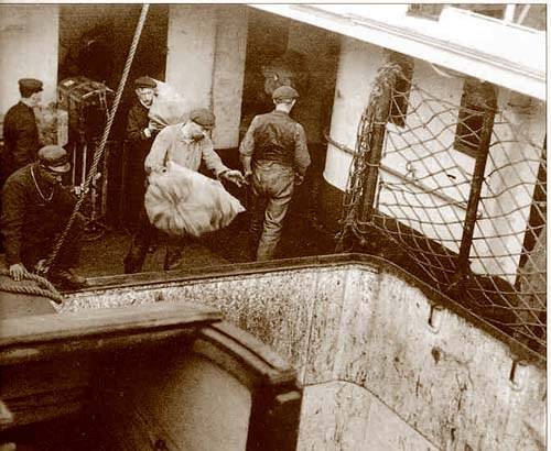 11 апреля 1912 года. Мешки с почтой заносят на борт Титаника в Куинстауне, и в буквальном смысле кидают их в отсек хранения почты, через передний угольный бункер.